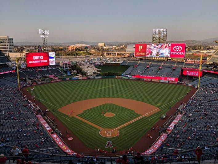 View of Angels Stadium from the stands, with a well-maintained field, scoreboards, and some people scattered in the seats.